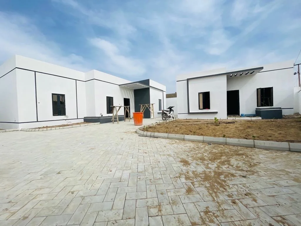 Renovated residential units around a shared courtyard, with white-and-dark façades, paving and a central open area.